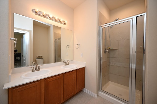 bathroom featuring tile patterned flooring, vanity, toilet, and an enclosed shower