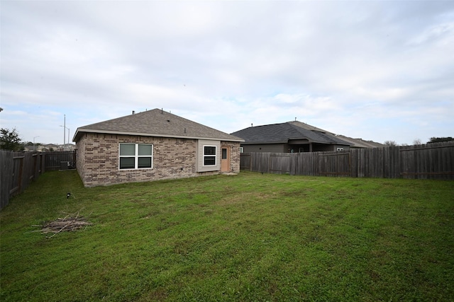 rear view of house featuring a yard