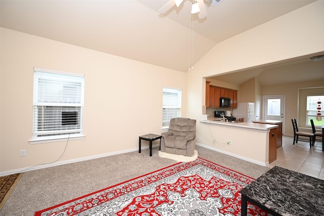 living area with ceiling fan, light colored carpet, and lofted ceiling