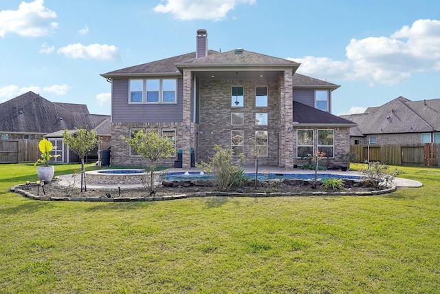 back of property with a swimming pool with hot tub, a patio, and a lawn