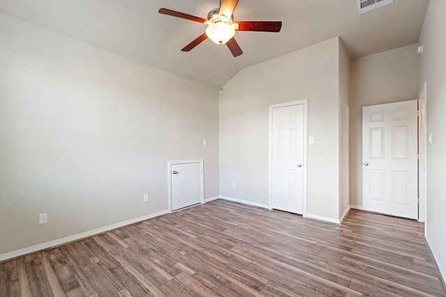 unfurnished bedroom with ceiling fan, a closet, wood-type flooring, and lofted ceiling