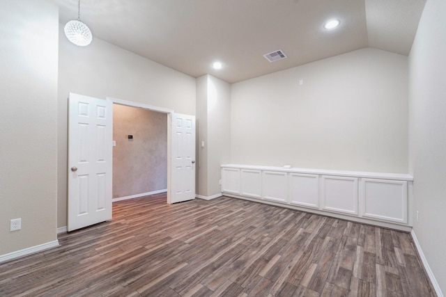 empty room featuring dark wood-type flooring and lofted ceiling