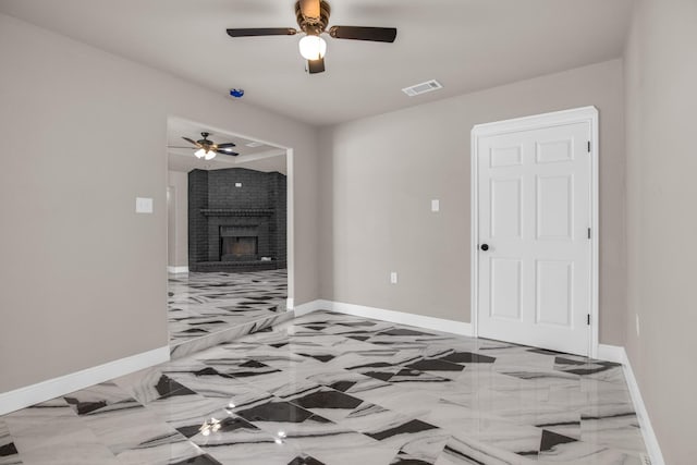 interior space featuring ceiling fan and a fireplace