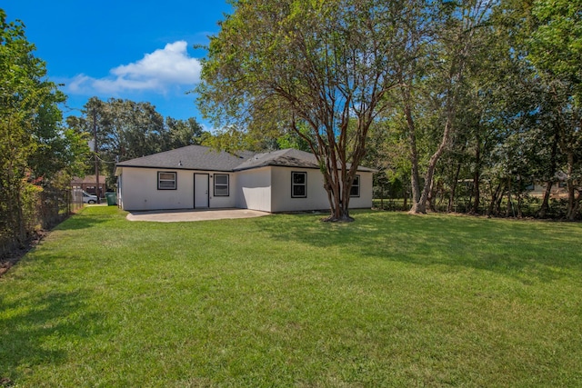 rear view of property with a yard and a patio area