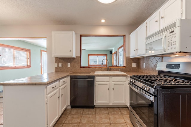 kitchen featuring dishwasher, white cabinetry, gas range, kitchen peninsula, and backsplash