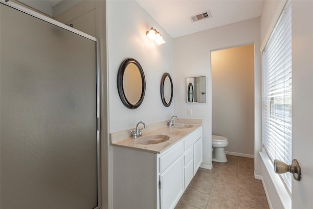 bathroom with vanity, toilet, and a shower with door