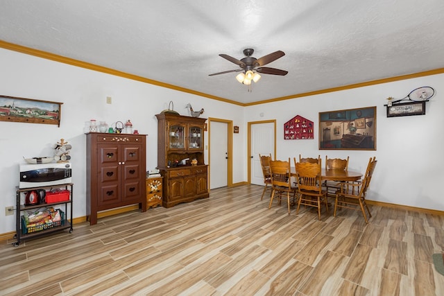 dining room featuring ceiling fan, ornamental molding, and a textured ceiling