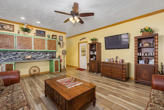 living room with ceiling fan, ornamental molding, a textured ceiling, and light hardwood / wood-style flooring