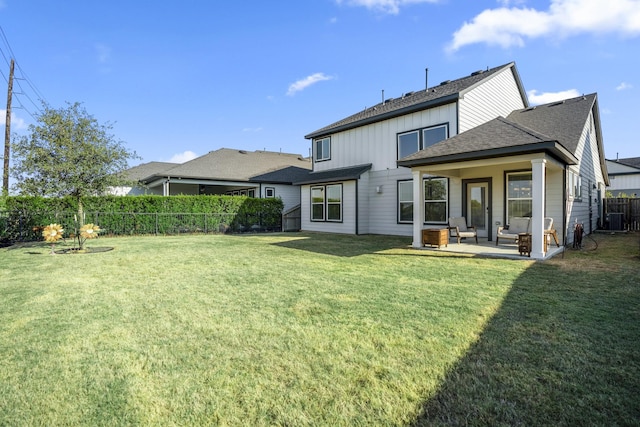 rear view of house with a patio area, a yard, and central AC unit