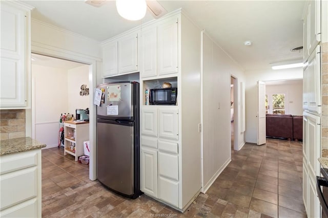 kitchen featuring light stone countertops, stainless steel fridge, white cabinetry, and ceiling fan