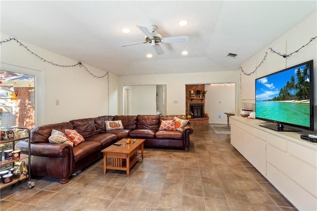 living room featuring a brick fireplace and ceiling fan