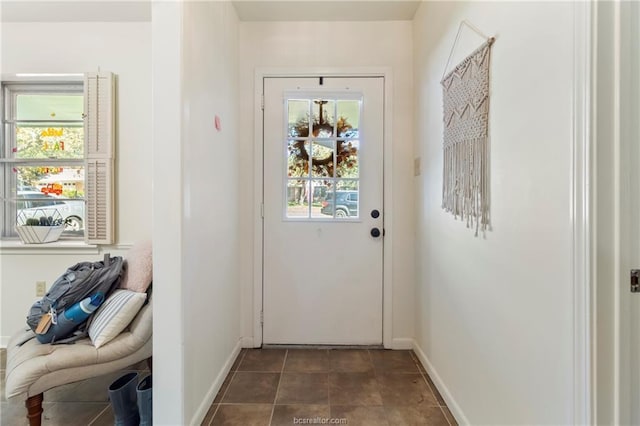 doorway with a healthy amount of sunlight and dark tile patterned flooring