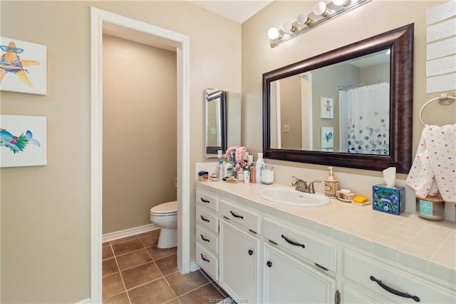 bathroom featuring tile patterned flooring, vanity, and toilet