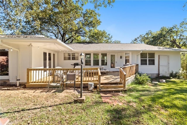 back of property with a lawn and a wooden deck