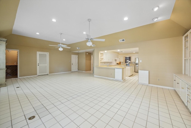 unfurnished living room with ceiling fan, light tile patterned floors, and lofted ceiling