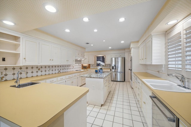 kitchen with dishwasher, stainless steel fridge, a center island, and sink