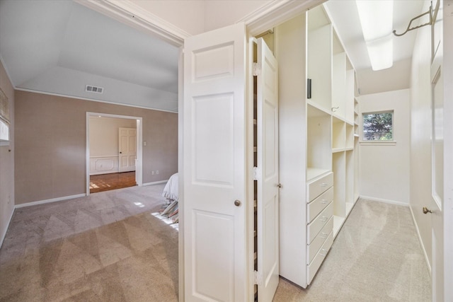 hall with light carpet and vaulted ceiling