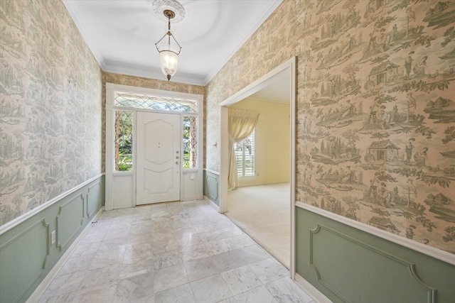 foyer with ornamental molding and light carpet