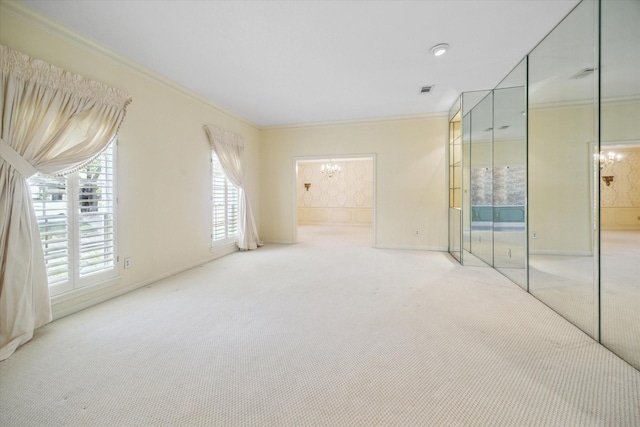 carpeted spare room with crown molding and an inviting chandelier