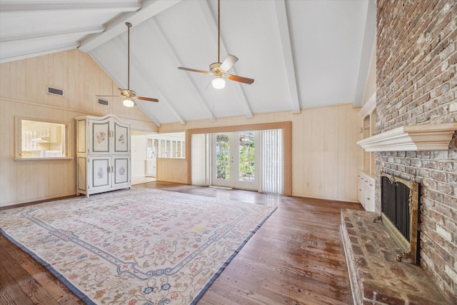 living room featuring ceiling fan, high vaulted ceiling, beamed ceiling, wood-type flooring, and a fireplace