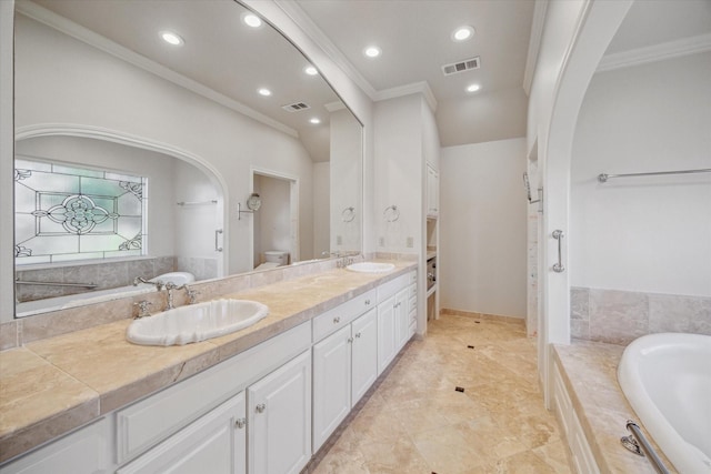 bathroom featuring vanity, toilet, crown molding, and tiled tub