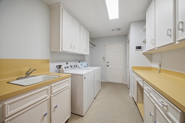 laundry area with cabinets, independent washer and dryer, and sink