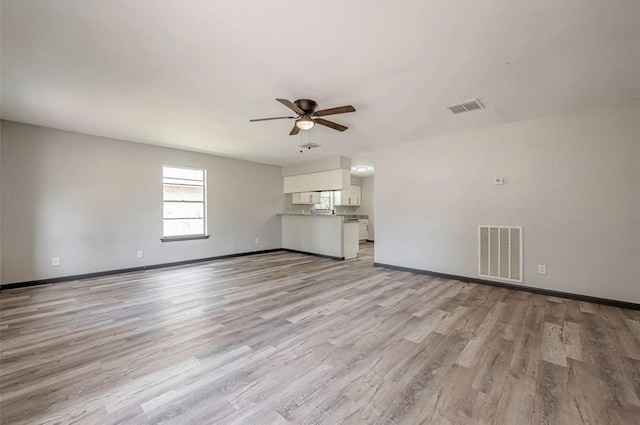 unfurnished living room featuring ceiling fan and light wood-type flooring