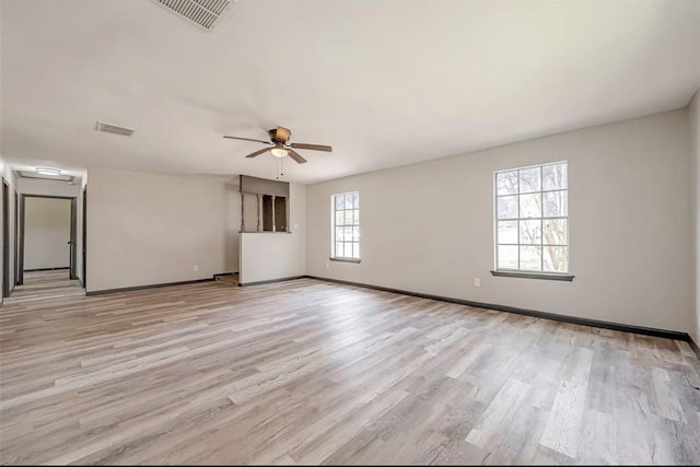 spare room with ceiling fan, plenty of natural light, and light hardwood / wood-style floors