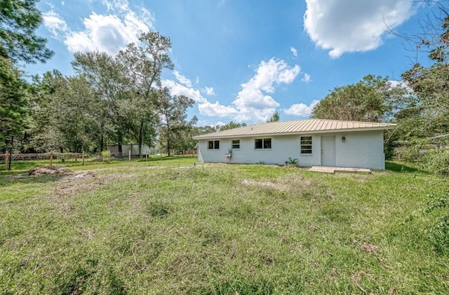 rear view of property featuring a yard