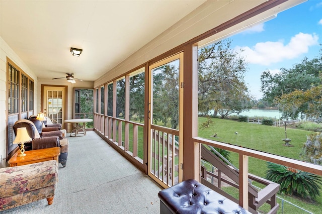 sunroom featuring a water view, a healthy amount of sunlight, and ceiling fan