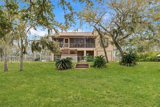 rear view of house with a sunroom and a lawn