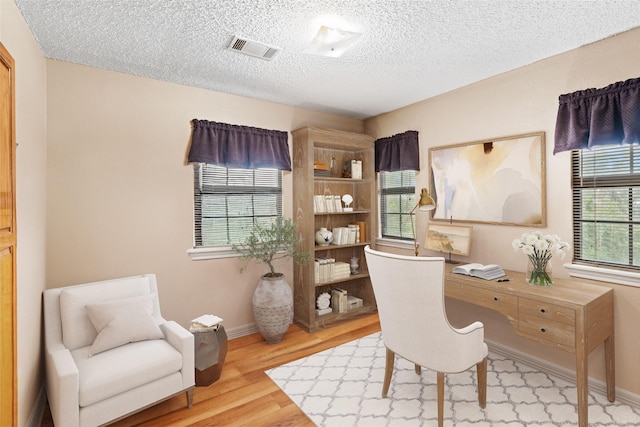 home office featuring a textured ceiling and hardwood / wood-style floors