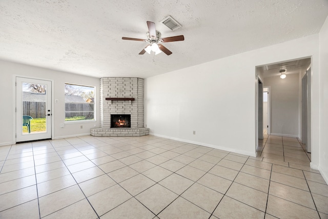 unfurnished living room featuring a fireplace, a textured ceiling, ceiling fan, and light tile patterned flooring