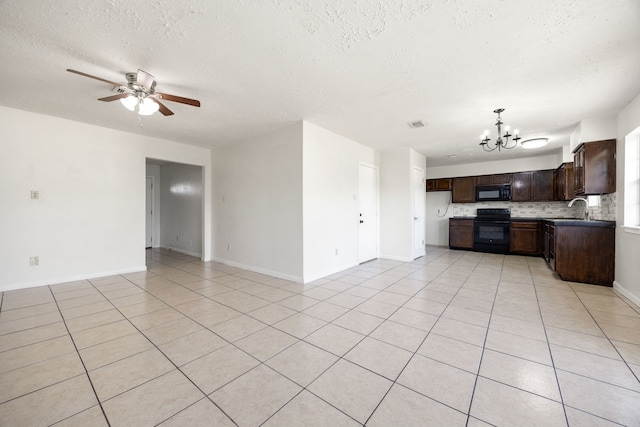 unfurnished living room featuring a textured ceiling, sink, light tile patterned floors, and ceiling fan with notable chandelier