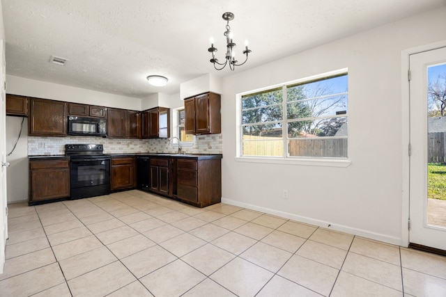 kitchen featuring pendant lighting, an inviting chandelier, black appliances, tasteful backsplash, and light tile patterned flooring