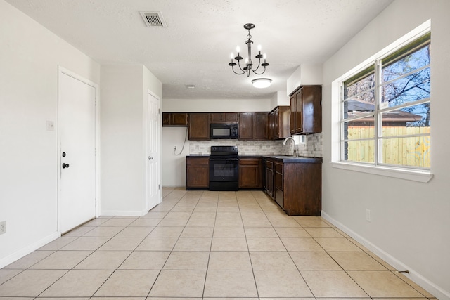 kitchen with tasteful backsplash, sink, black appliances, pendant lighting, and an inviting chandelier