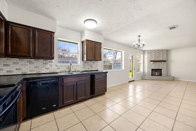 kitchen featuring black appliances, sink, a fireplace, a textured ceiling, and tasteful backsplash