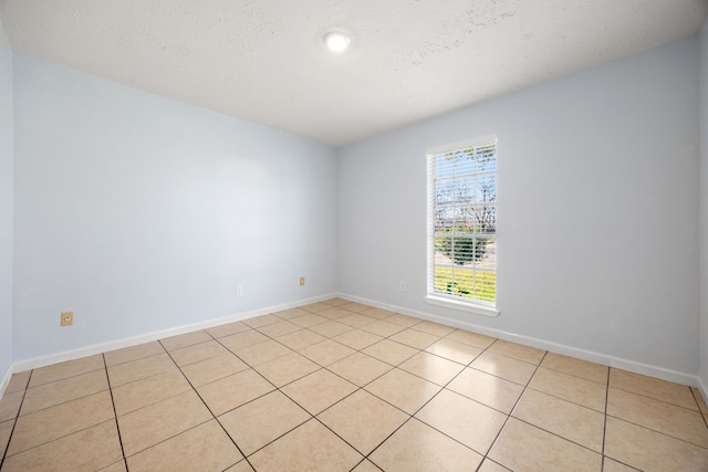 tiled spare room with a textured ceiling