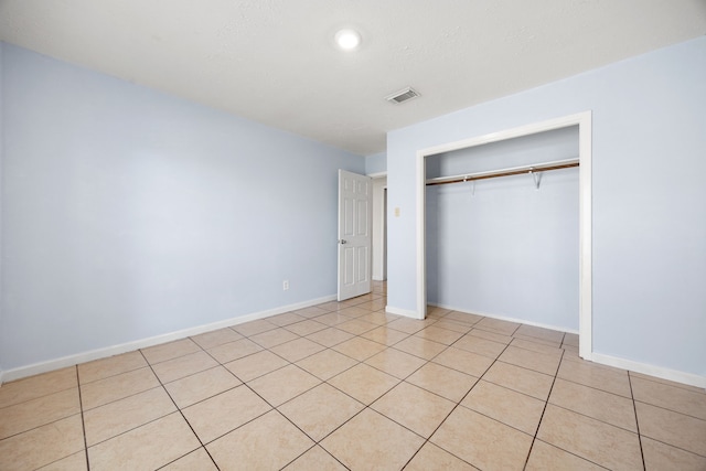 unfurnished bedroom with a closet and light tile patterned flooring