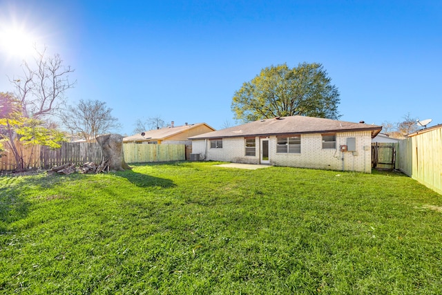 back of property with central air condition unit and a lawn