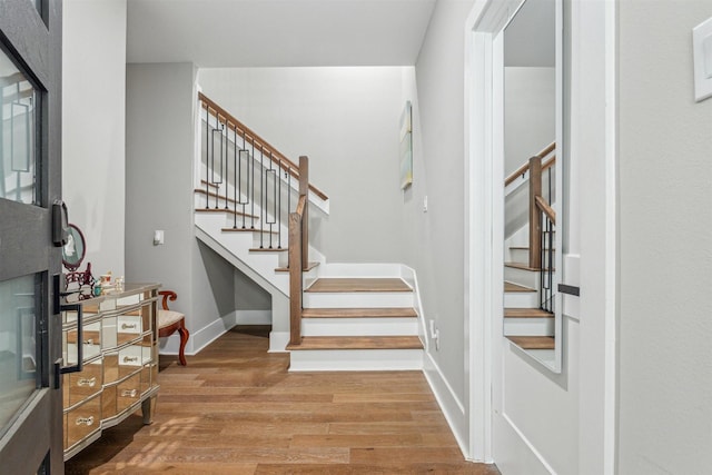 staircase featuring baseboards and wood finished floors