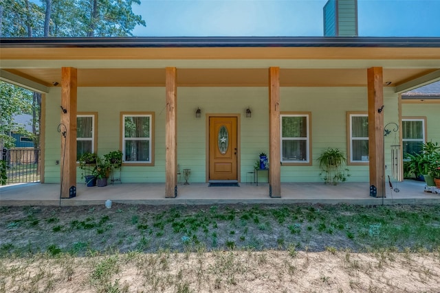 view of exterior entry featuring covered porch