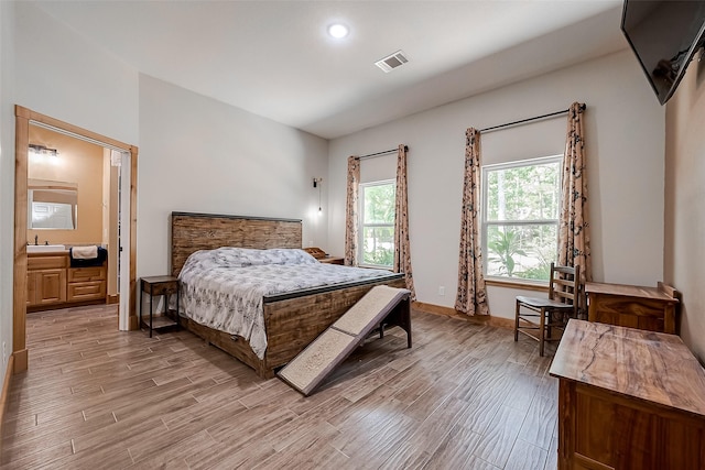 bedroom featuring connected bathroom and sink