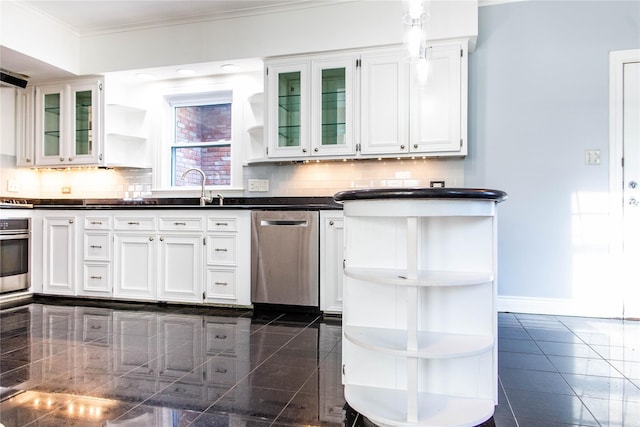 kitchen with decorative backsplash, appliances with stainless steel finishes, white cabinetry, and sink