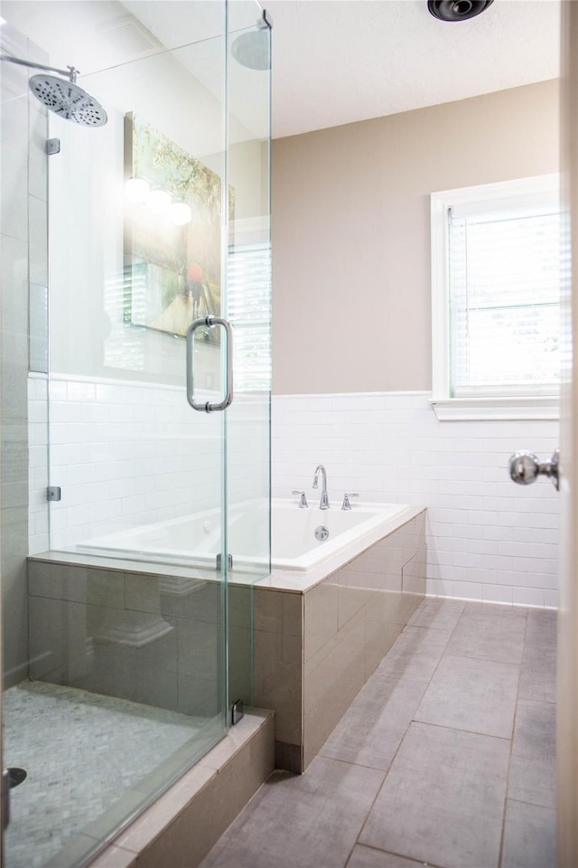 bathroom with tile patterned floors, a healthy amount of sunlight, and shower with separate bathtub