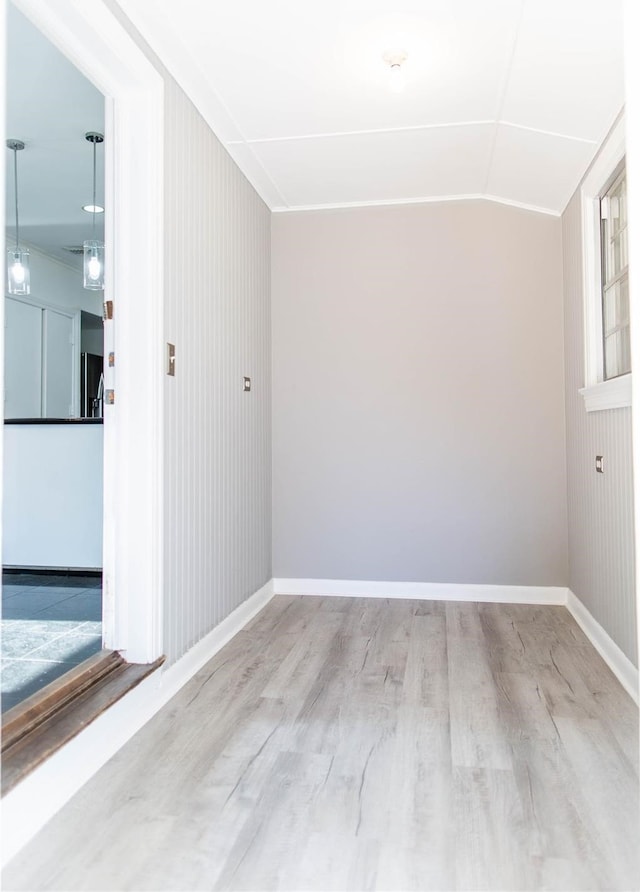 unfurnished room featuring lofted ceiling and light hardwood / wood-style flooring