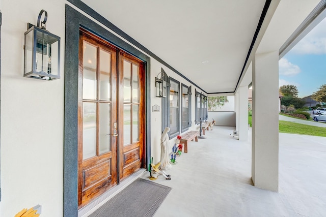 view of exterior entry featuring french doors and stucco siding