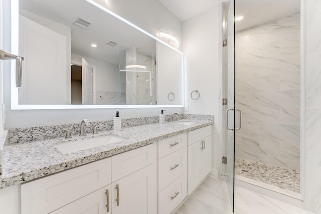 bathroom featuring marble finish floor, a sink, visible vents, and a shower stall