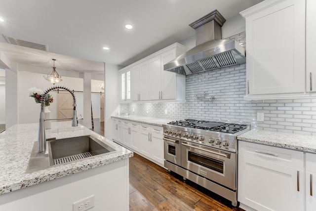 kitchen with white cabinets, wall chimney range hood, decorative backsplash, double oven range, and sink