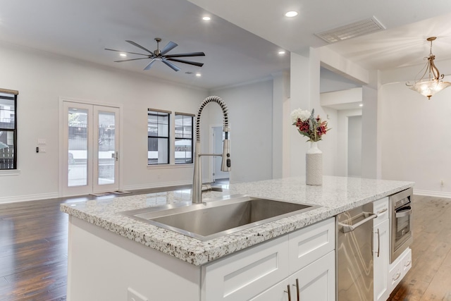 kitchen featuring white cabinetry, ceiling fan, hanging light fixtures, ornamental molding, and sink